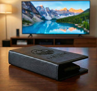 Personalized black full-grain leather TV remote case with custom embossed Memories Made logo for luxury home organization.