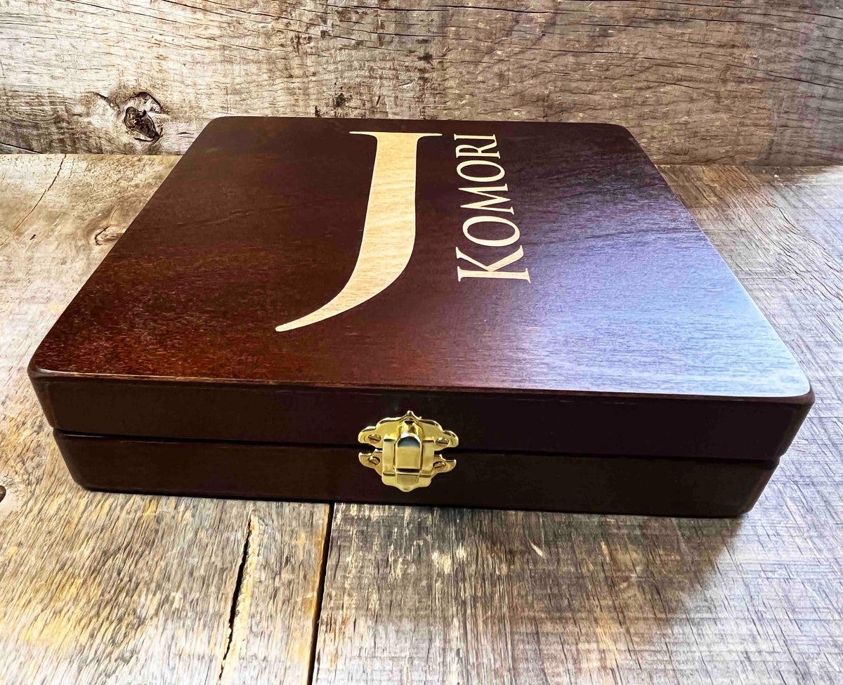 Wooden jewelry box with 'Komori' branding on a wooden surface