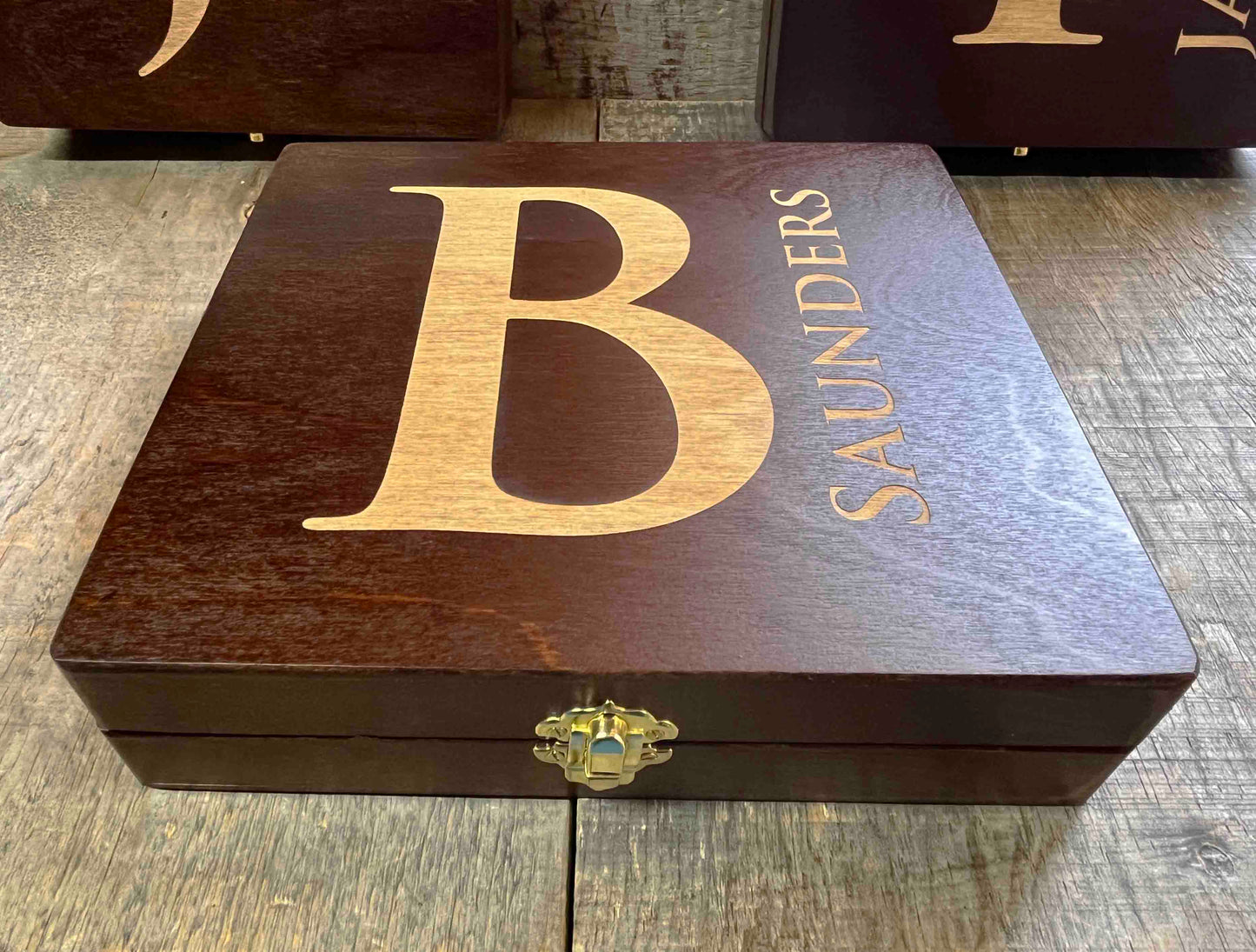 Wooden box with 'B Saunders' engraving on a wooden surface