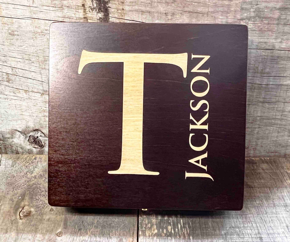 Wooden sign with 'T' and 'Jackson' engraved on a rustic wooden background