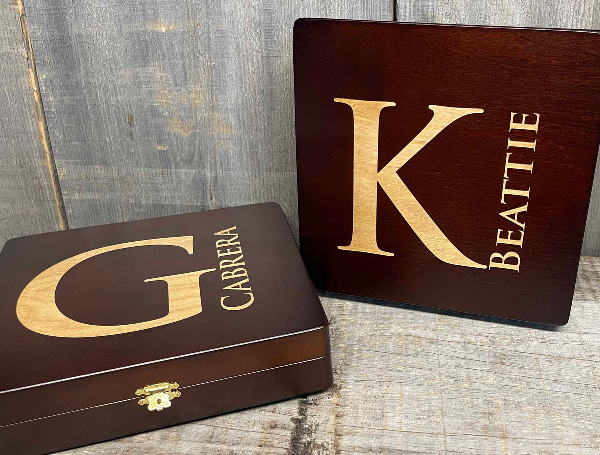 Two wooden boxes with gold lettering on a rustic wooden surface