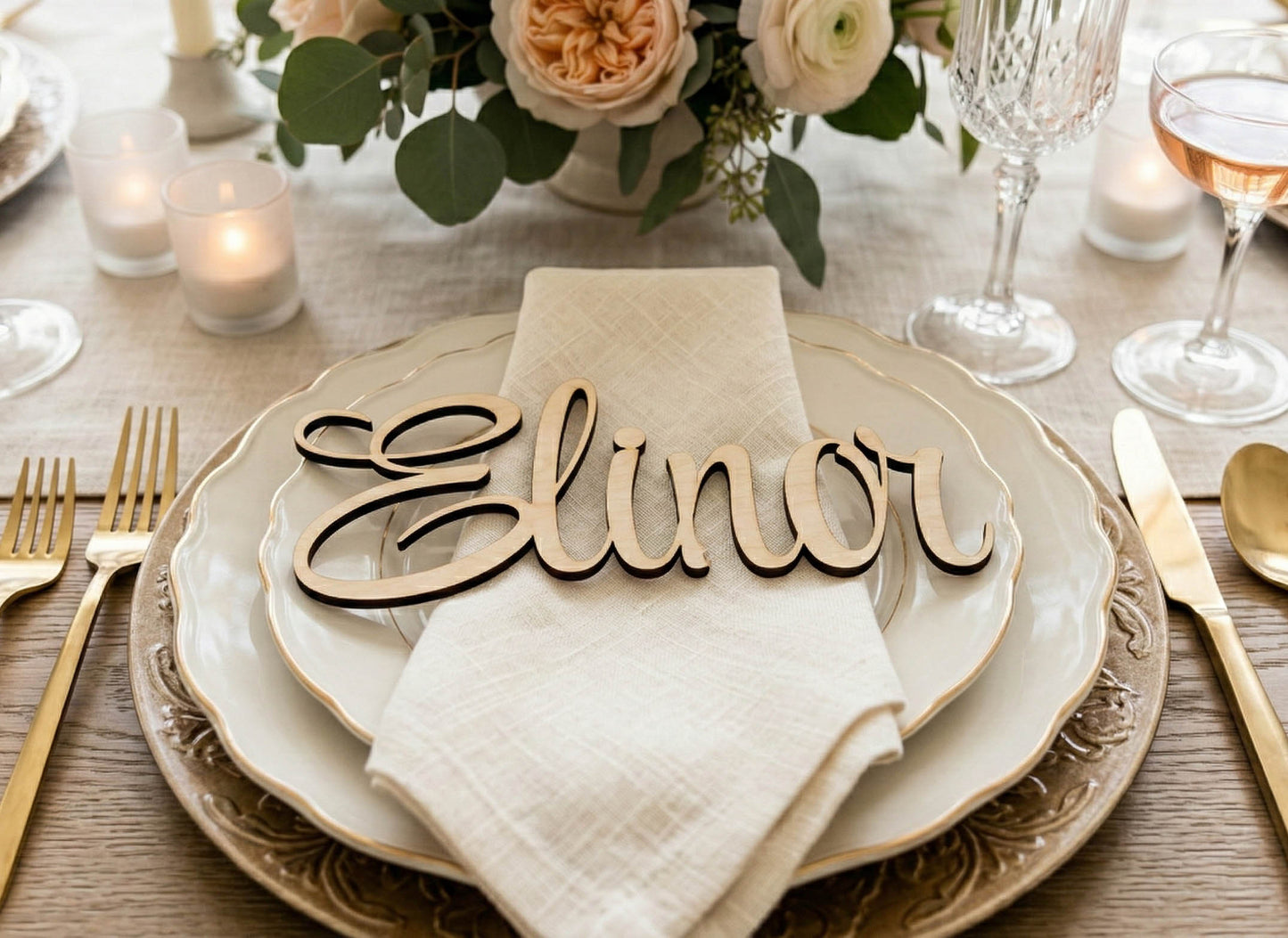 Table setting with 'Elinor' name card, plates, and cutlery on a wooden table.