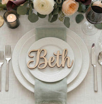 Table setting with a name card reading 'Beth' on a white plate.