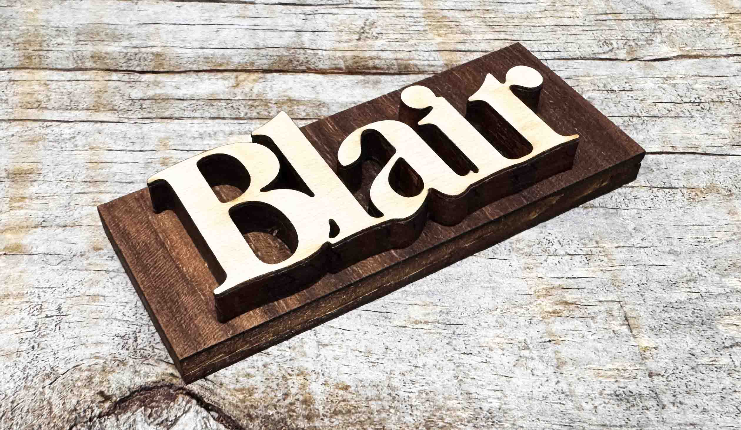 Wooden nameplate with 'Blair' engraved on a wooden surface