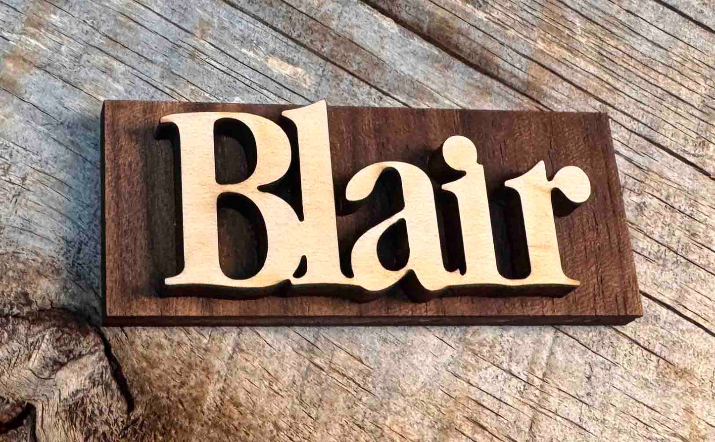 Wooden nameplate with 'Blair' on a wooden background