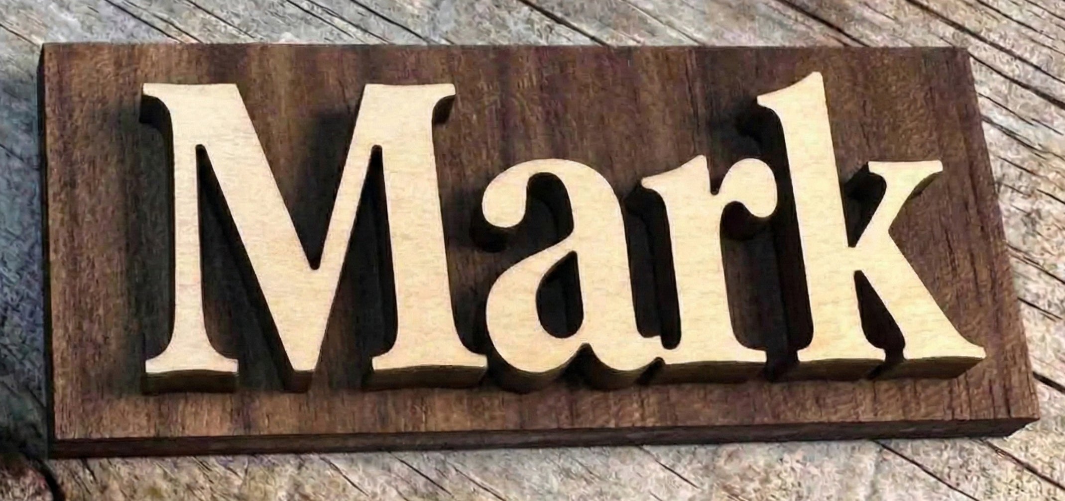 Wooden sign with the name 'Mark' on a wooden surface