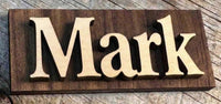Wooden sign with the name 'Mark' on a wooden surface